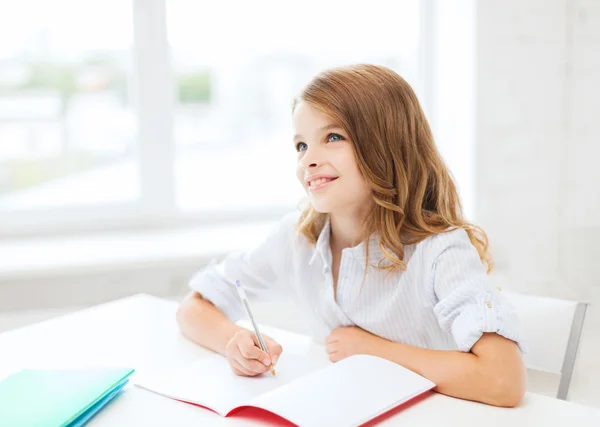 Φοιτητής κορίτσι εγγράφως στο σημειωματάριο στο σχολείο — Φωτογραφία Αρχείου