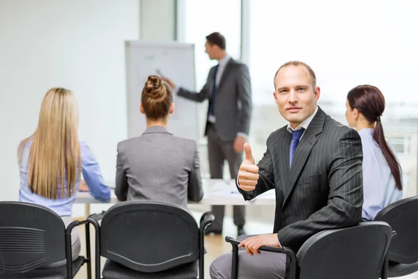 Uomo d'affari con il team che mostra i pollici in alto in ufficio — Foto Stock