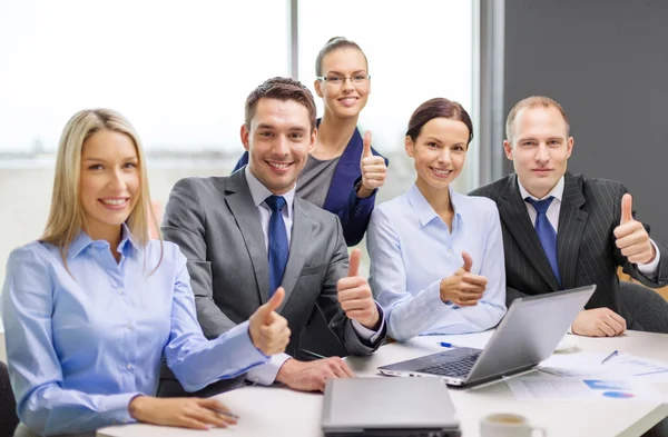 Business team showing thumbs up in office Stock Photo