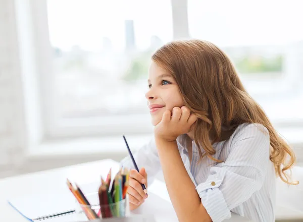 Weinig student meisje tekenen en dromen op school — Stockfoto