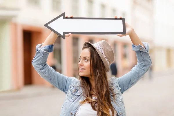 Menina mostrando direção com seta na cidade — Fotografia de Stock