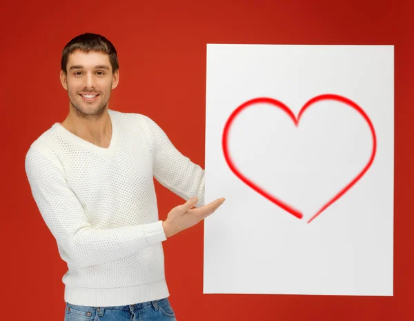 Hombre guapo sosteniendo gran tablero con corazón — Foto de Stock