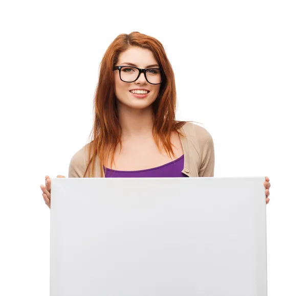 Smiling girl with eyeglasses and white blank board — Stock Photo, Image