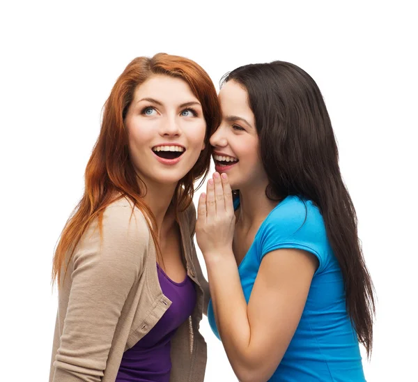 Two smiling girls whispering gossip — Stock Photo, Image