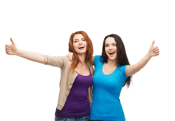 Две улыбающиеся девушки, показывающие большие пальцы вверх — стоковое фото