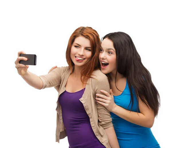 Två leende tonåringar med smartphone — Stockfoto