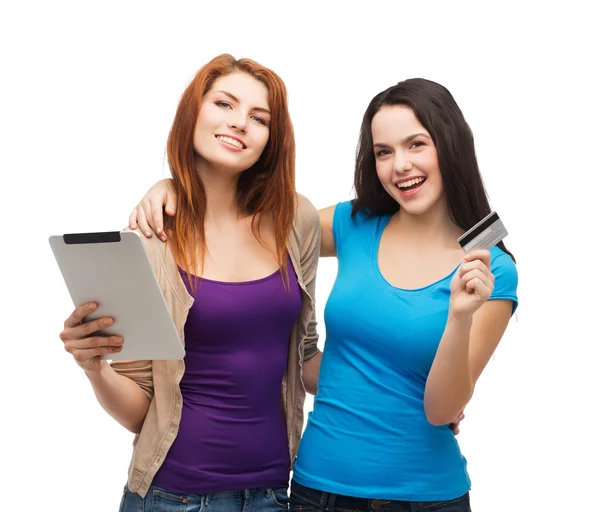 Две улыбающиеся девушки с планшетным ПК и кредитной картой — стоковое фото