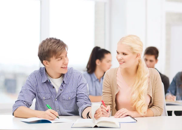 Två tonåringar med bärbara datorer och bok i skolan — Stockfoto