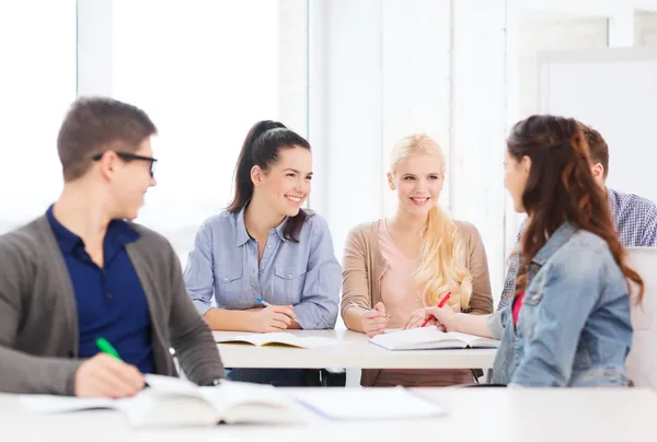 Two teenagers with notebooks and book at school — Stock Photo, Image