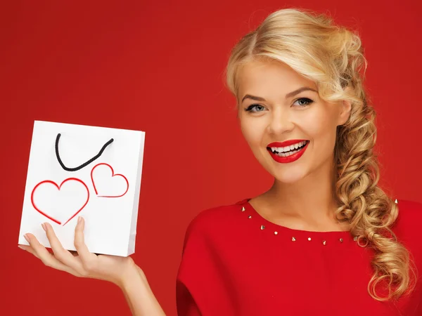 Preciosa mujer en vestido rojo con bolsa de compras —  Fotos de Stock