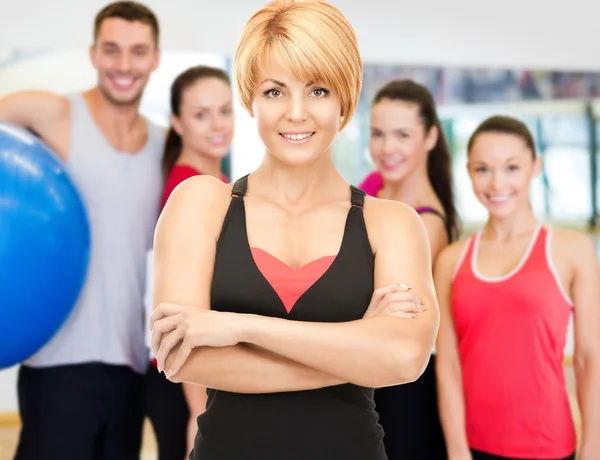 Grupo de personas sonrientes haciendo ejercicio en el gimnasio —  Fotos de Stock