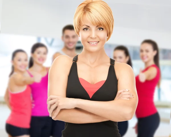 Grupo de personas sonrientes haciendo ejercicio en el gimnasio —  Fotos de Stock