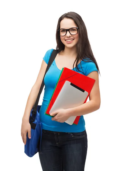 Estudiante sonriente con bolsa, carpetas y tableta pc — Foto de Stock