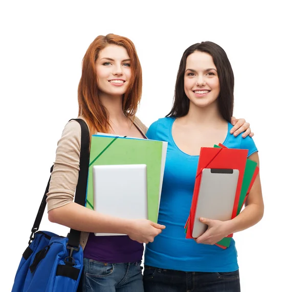 Dos estudiantes sonrientes con bolsa, carpetas y tableta — Foto de Stock