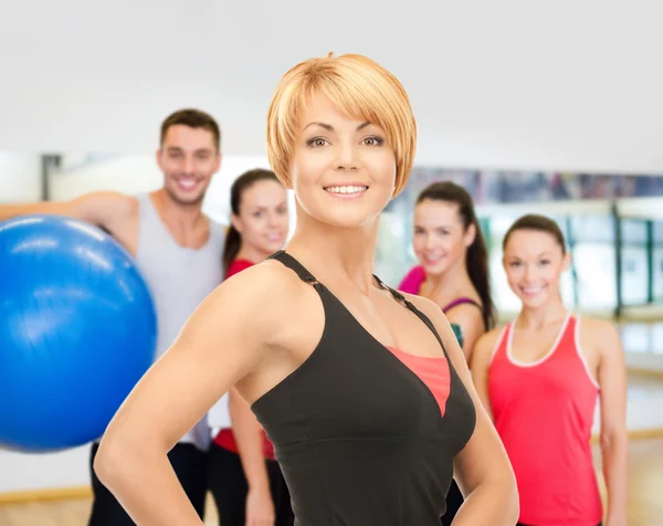 Grupo de personas sonrientes haciendo ejercicio en el gimnasio —  Fotos de Stock