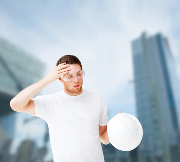 Manliga arkitekt i skyddsglasögon lyfter hjälm — Stockfoto