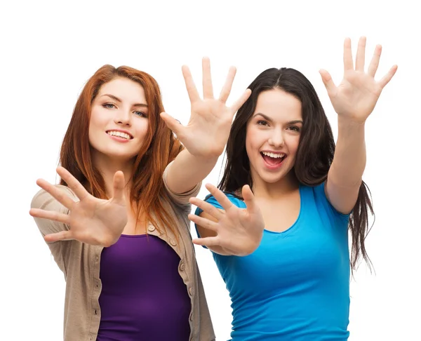 Twee lachende meisjes tonen hun palmen — Stockfoto
