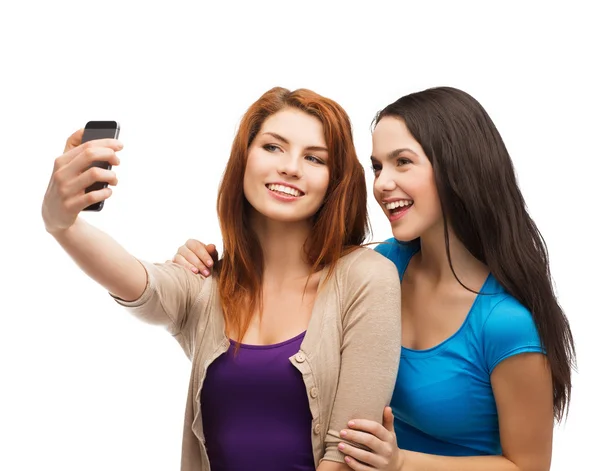 Two smiling teenagers with smartphone — Stock Photo, Image