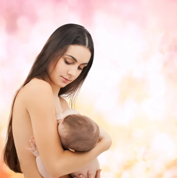 Mãe feliz alimentando seu bebê adorável — Fotografia de Stock