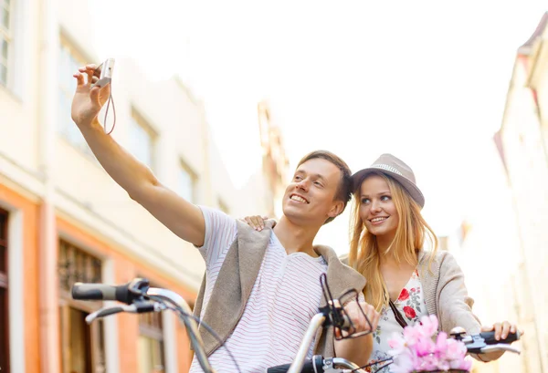 Casal com bicicletas tirando foto com câmera — Fotografia de Stock