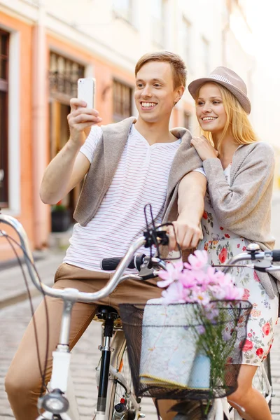 Coppia con biciclette e smartphone in città — Foto Stock