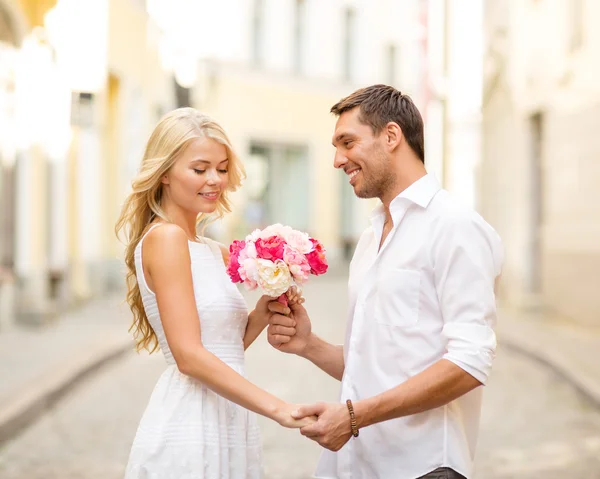 Couple avec des fleurs dans la ville — Photo