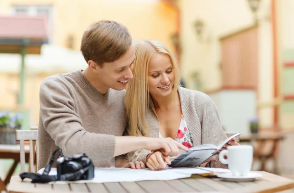 Couple with map, camera, city guide and coffee — Stock Photo, Image