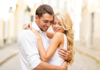 Romantic happy couple hugging in the street clipart