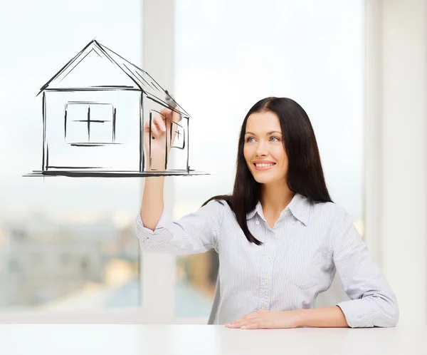 Lachende vrouw huis puttend uit virtuele scherm — Stockfoto