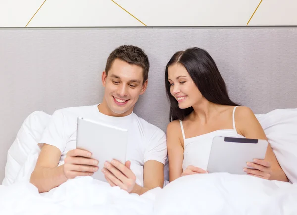 Ler par i sängen med tablet pc-datorer — Stockfoto