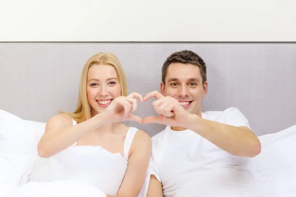 Smiling couple showing heart with hands — Stock Photo, Image