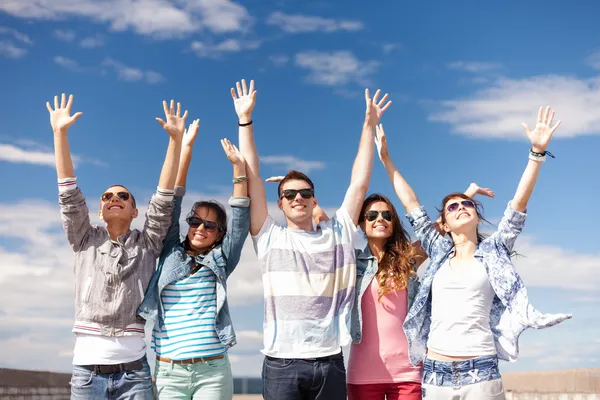 Groep van lachende tieners bedrijf in handen — Stockfoto