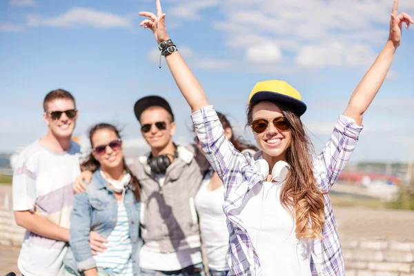 Adolescente avec écouteurs et amis à l'extérieur — Photo