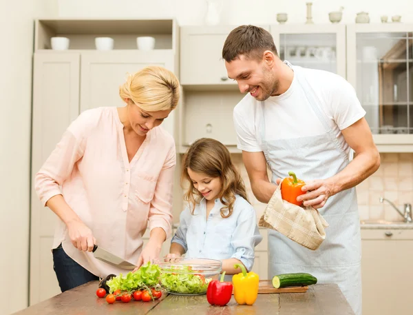 Feliz família fazendo o jantar na cozinha — Fotografia de Stock