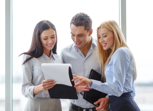 Equipo de negocios mirando el portapapeles —  Fotos de Stock