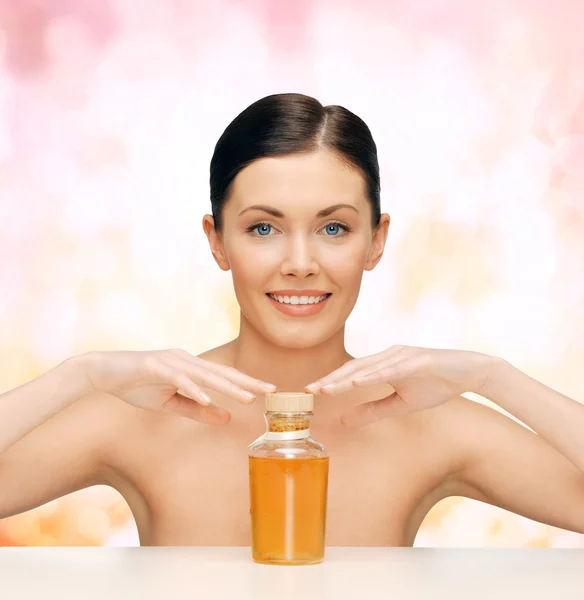 Hermosa mujer con botella de aceite — Foto de Stock