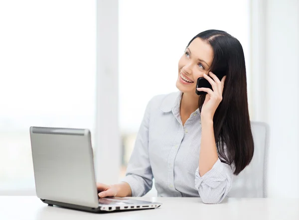 Affärskvinna med laptop och mobiltelefon — Stockfoto