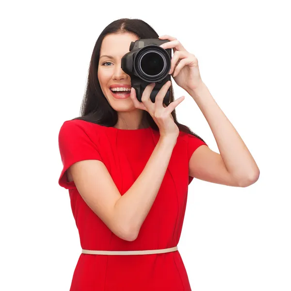 Femme souriante prenant des photos avec un appareil photo numérique — Photo