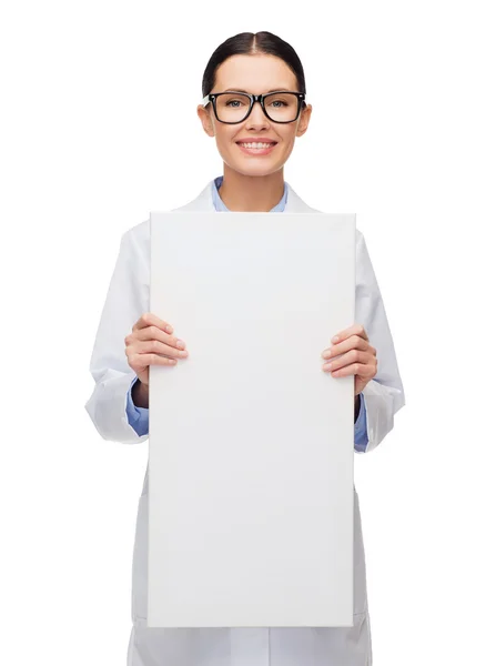 Female doctor in eyeglasses with white blank board — Stock Photo, Image