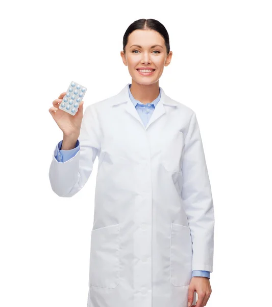 Leende kvinna läkare med piller — Stockfoto