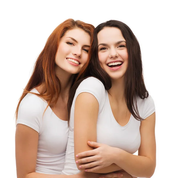 Two laughing girls in white t-shirts hugging — Stock Photo, Image