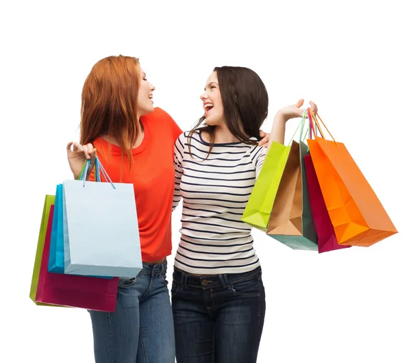 Two smiling teenage girls with shopping bags — Stock Photo, Image