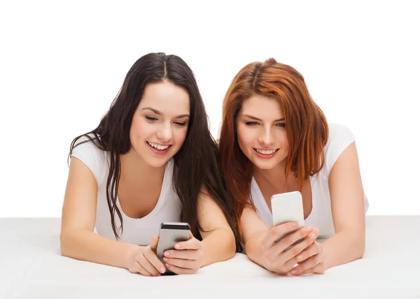 Twee lachende tieners met smartphones — Stockfoto