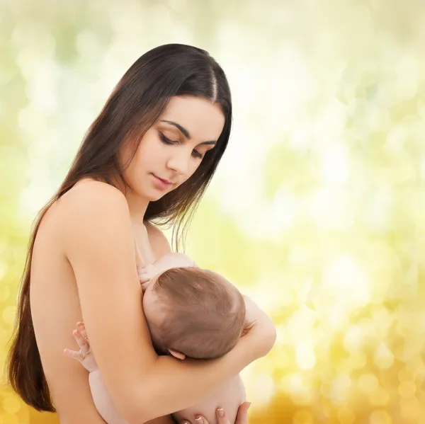 Mãe feliz alimentando seu bebê adorável — Fotografia de Stock