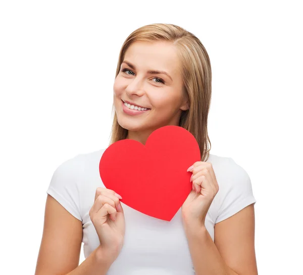 Улыбающаяся женщина в белой футболке с сердцем — стоковое фото