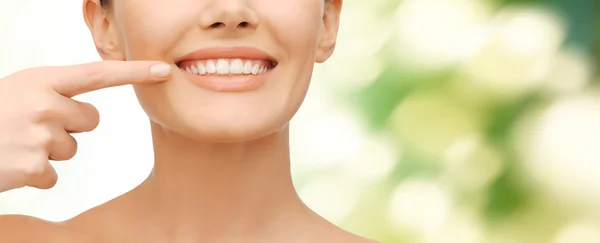 Beautiful woman pointing to teeth — Stock Photo, Image