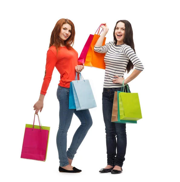 Two smiling teenage girls with shopping bags — Stock Photo, Image