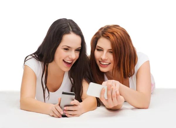 Due adolescenti sorridenti con gli smartphone — Foto Stock