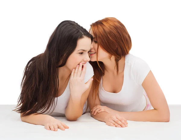 Two smiling girls whispering gossip — Stock Photo, Image