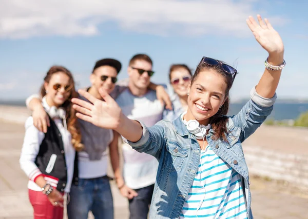 Adolescente chica con auriculares y amigos fuera —  Fotos de Stock